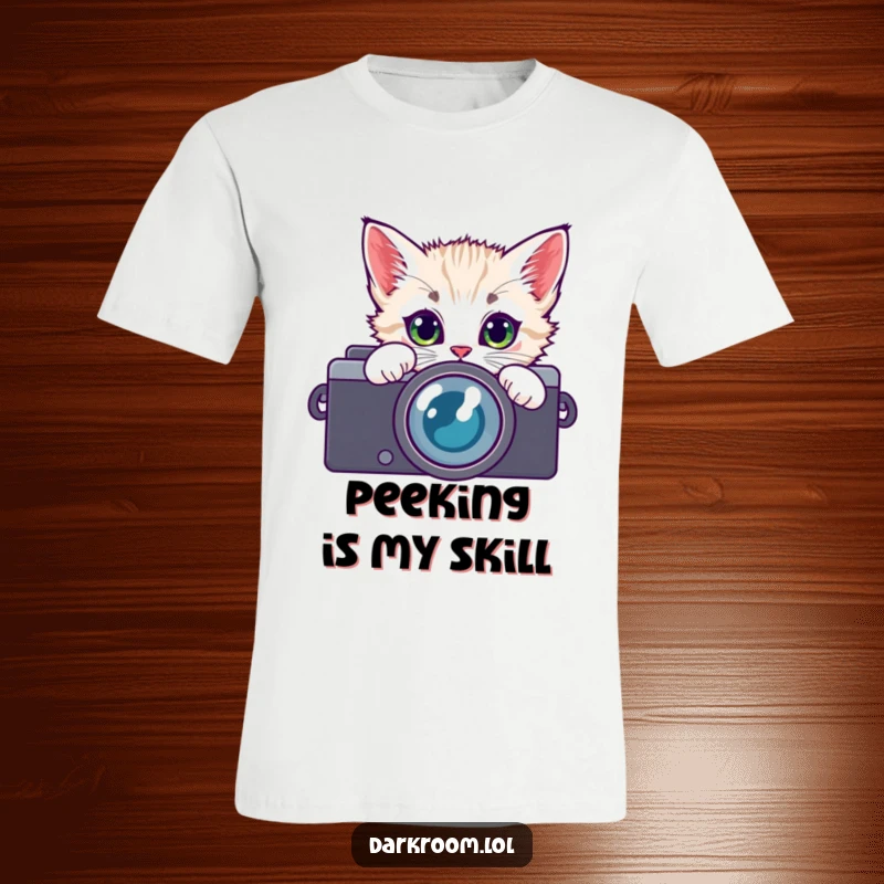 Funny kitten wearing a camera lens t-shirt, peeking with wide, curious eyes, representing a playful and artistic photographic perspective.