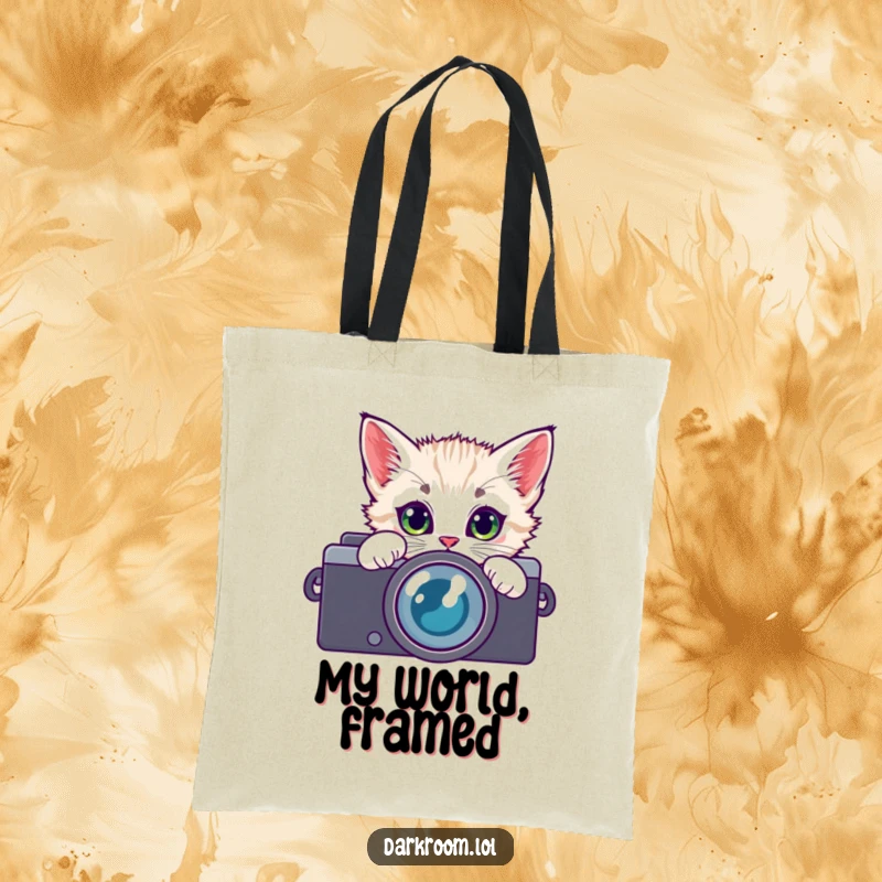 Funny kitten photographer tote bag, peeking through a camera lens with curious eyes, ideal for carrying daily essentials with feline flair.